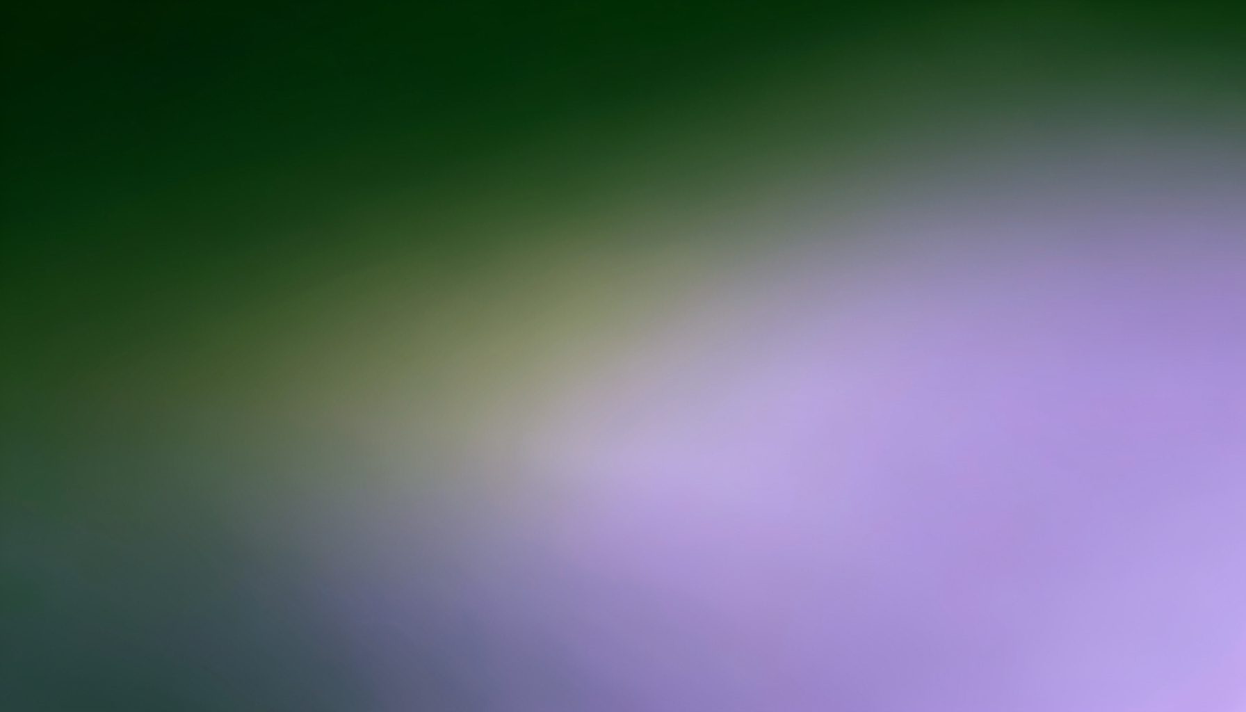 A wide horizontal band with a smooth gradient blending deep forest green through muted olive into soft lavender-purple, creating an atmospheric abstract transition.
